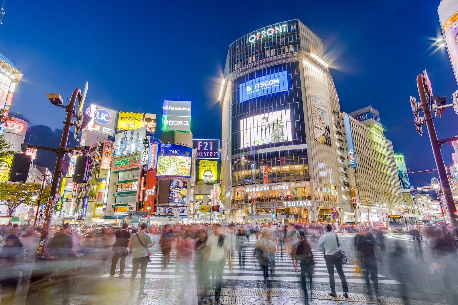 Menschen auf der beleuchteten Shibuya-Kreuzung in Tokio